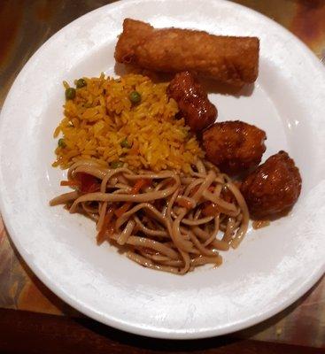 Asian selections, egg roll, orange chicken, yellow rice & peas, noodles.