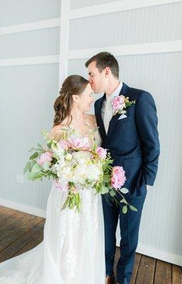 Bride and groom, groom kissing the brides forehead.