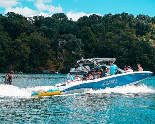 a group of kids watching their friend do the water sport wakesurfing on Candlewood Lake, Connecticut