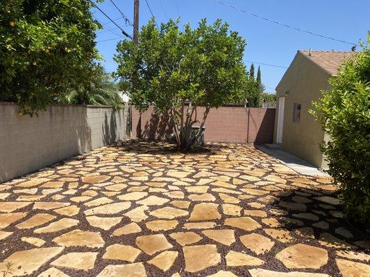 New back yard patio landscape. Installation of step stones with red volcanic stone fillers .