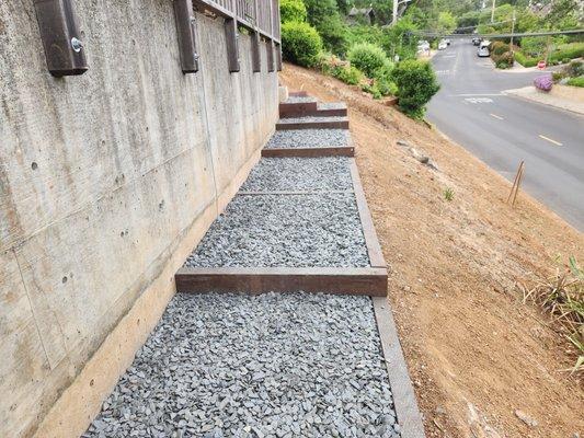 Pathway installed along top of the hillside.  Pressure treated 4"X6" wood beams were used which were secured with ¾" round by 24" long steel