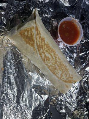 Breakfast burrito with egg, cheese, hash browns, onions, and really good bacon along with some Pace picante sauce.