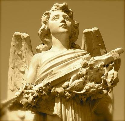 Angel holding a cross and looking towards the heavens.