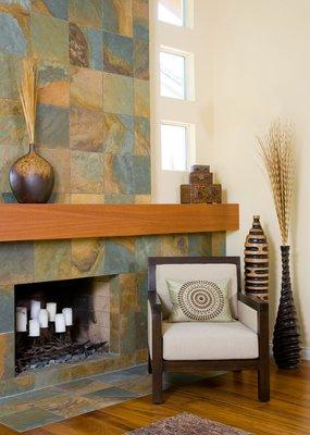 Warm contemporary asymmetyric slate-limestone fireplace with three stacked windows and large wood mantle.