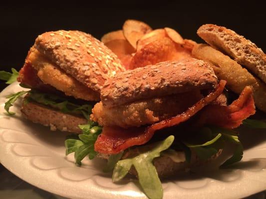 Fried green tomato sandwich with bacon, arugula and grilled corn mayo on whole grain bun.