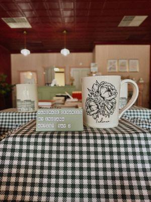 Handmade ceramic mugs, cups, juicers, and more sold at The Pearl Plate. The artist behind these products is Sav J Art, an Indiana artist.