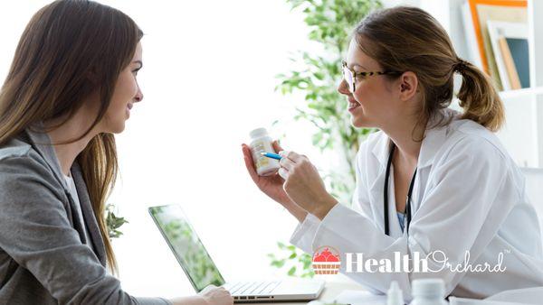 Women speaking with doctor about supplements with Health Orchard logo in background.