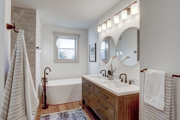 Master bathroom design with soaking tub, double vanity, large tiled shower, hardwood floors.