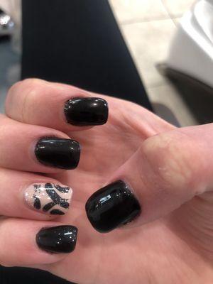 square acrylics with black nail polish and design on ring finger