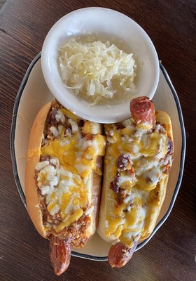 Hot dog layered in Chili and different cheeses.