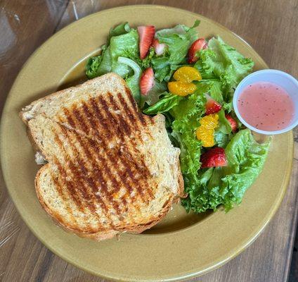 Chicken salad panini and fresh greens with mandarin oranges and strawberries served with the Farmhouse salad dressing.