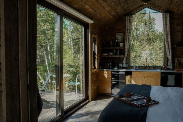 Forest views from king bed, sunrise peaking in studio cabin rentals Tofte Trails Minnesota north Shore