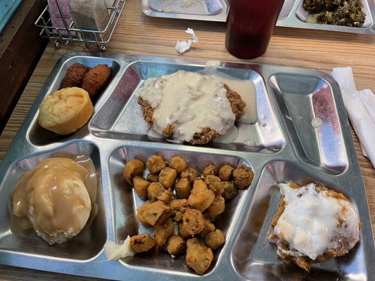 country fried steak with white gravy, sweet potato soufflé, fried okra, mashed potatoes & gravy, cornbread, hushpuppies