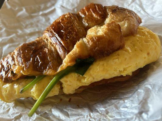 Egg sandwich on croissant with bacon and spinach