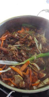 Brown stew chicken being cooked