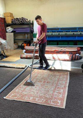 Vacuuming a rug with a high power vacuum