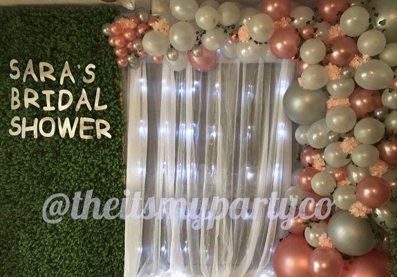 Grass wall, pipe and drapes with lights and organic balloon garland