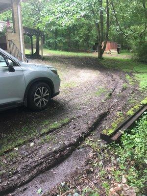 Another view of 6" deep ruts and one of many moved and crushed railroad ties that previously were a lovely garden. Car for scale.