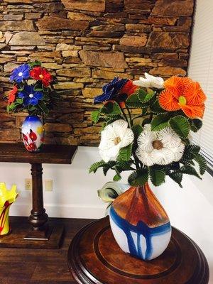 Sassy Glamour, Sophisticate arrangement of 9 Andreas flowers on orange, dark blue and white colors. 24" H x 14" W Glassblowing vase.