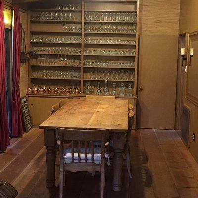 Dining table, and collection of glasses, just outside kitchen, and living room.