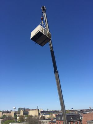 Condenser being craned on a roof top