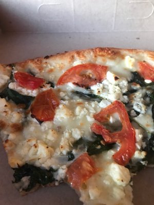 Pizza with feta, tomatoes and spinach.