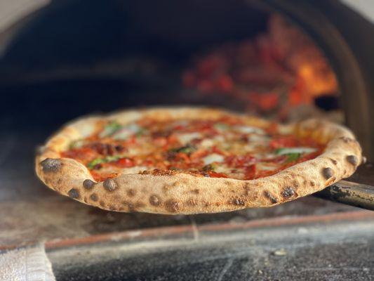 Finishing a pizza in one of our mobile wood-fired ovens