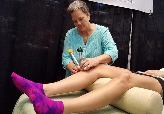 Using tuning forks on acupuncture points on the body in a private sound healing session.