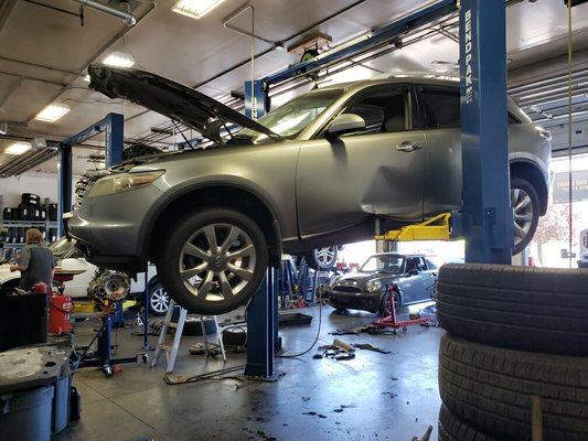 Car inside of Mechanics Pride shop in Spokane Valley hanging from their hoist.