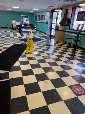 Dining area in background and social distancing spots on floor near ordering area