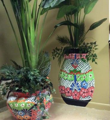 Painted pot and plant on wall behind the real pot