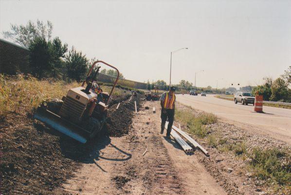 Roadside Irrigation Serviceman with Trencher Ready to Lay Pipe