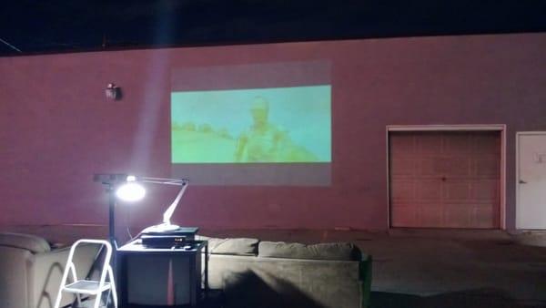 Movie Night at Studio M.  Star Wars (original episode) projected on a parking lot wall.  JDB Consultants sponsored BBQ.