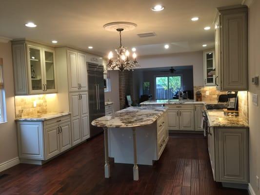 After pic 3 - overall kitchen with nice new island countertops, cabinets, lighting, flooring and paint.