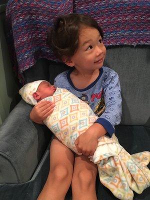 One of our patients holding his newborn brother after his first treatment!