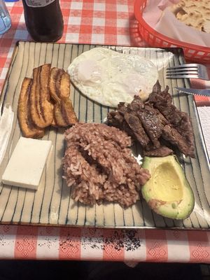 Salvadorian breakfast  Rice mixed with beans, steak, eggs, avocado, fried plantains, cheese and tortillas.