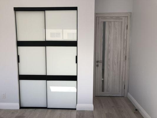 Black and white glass sliding doors for closet by A&E modern construction