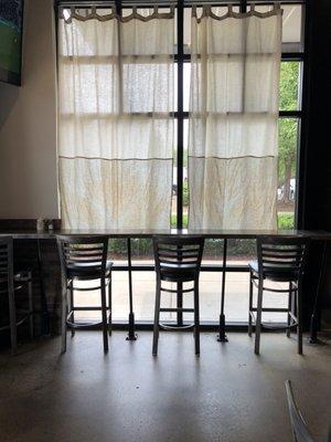 Bar seating inside the restaurant by the window.