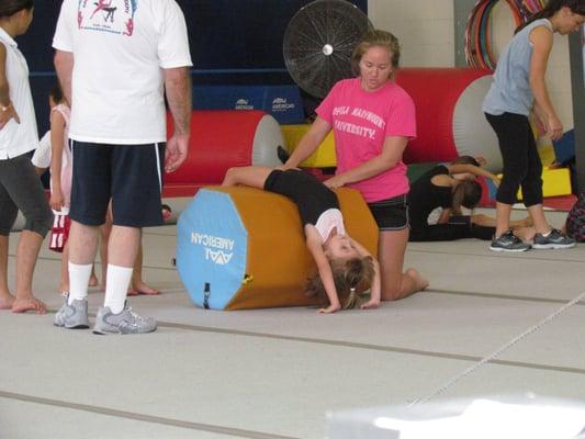 Using the gymnastics roller to increase flexibility.