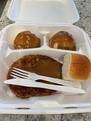 Hamburger steak with mashed potatoes x 2 and a roll.