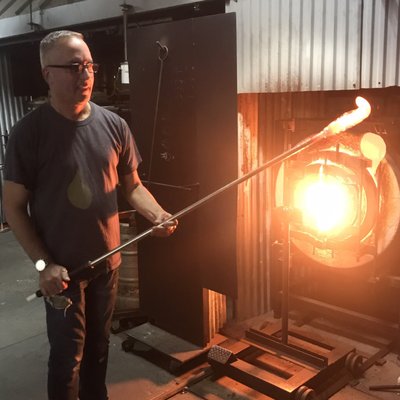 Phil at the glory hole where he melts the colors into the paperweight.