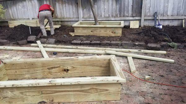 Custom wooden flower beds in the make.