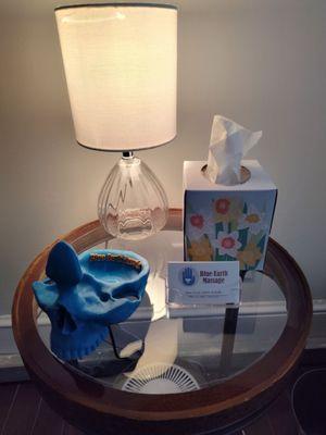 Side table with skull eye glass holder and business cards at Blue Earth Massage.