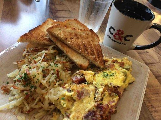 Meat omelette with jalapeños added and a side of hash browns, toast and cup of coffee.