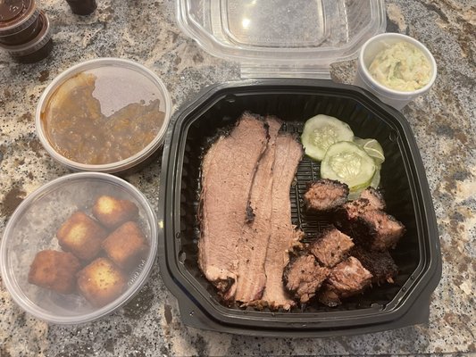 2 meat platter with three slices of brisket and seven burnt ends. Bbq beans and cornbread bites for $31.95. What a joke.