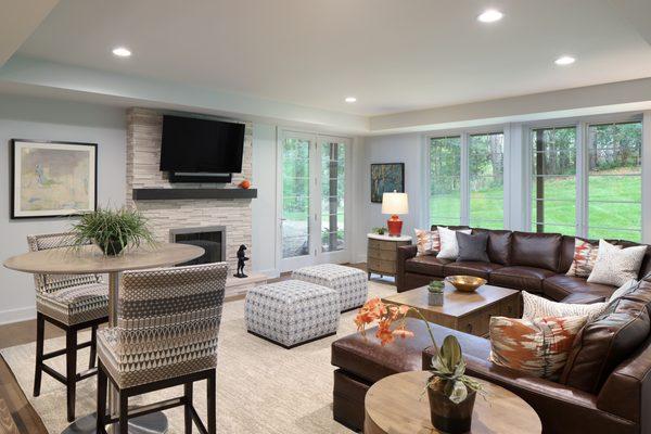 The accents of orange and the intricate patterns (Brentano Majalis Cardamon featured on Kravet Groton stools) create interest in the space.