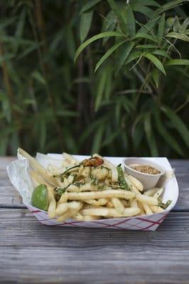 Fries topped with shishito peppers and cilantro and served with sweet chili aioli