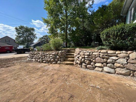 Dry stack 12-18" boulder wall with 4-5' sandstone outcropping natural steps