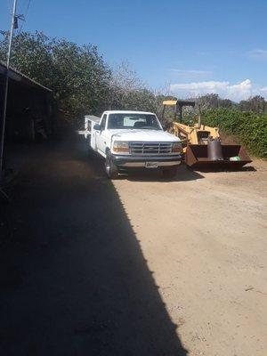 A tractor in progress of repair with the company service truck