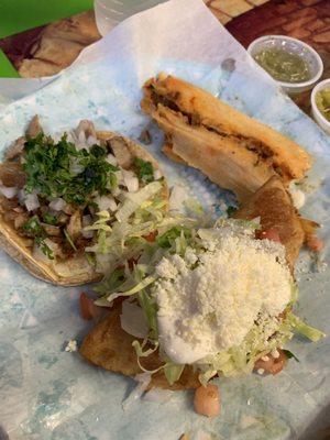 Empanada with sour cream and toppings, taco, and tamale